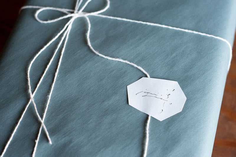 包装紙がブルーグレー、紐がホワイトの組み合わせ。